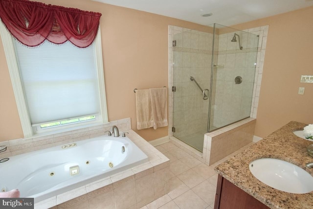 bathroom featuring a sink, a jetted tub, a shower stall, tile patterned flooring, and double vanity