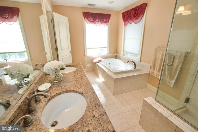 bathroom with visible vents, a jetted tub, a wealth of natural light, tile patterned floors, and a sink