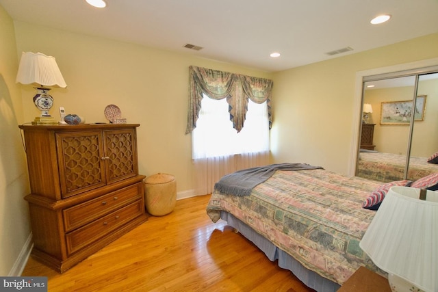 bedroom featuring visible vents, baseboards, light wood-type flooring, recessed lighting, and a closet