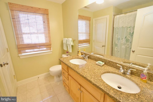 bathroom with tile patterned flooring, toilet, baseboards, and a sink