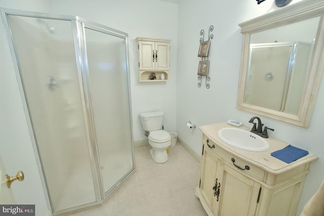 full bath with toilet, a shower stall, tile patterned flooring, baseboards, and vanity