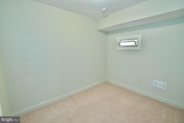 carpeted empty room with visible vents and baseboards