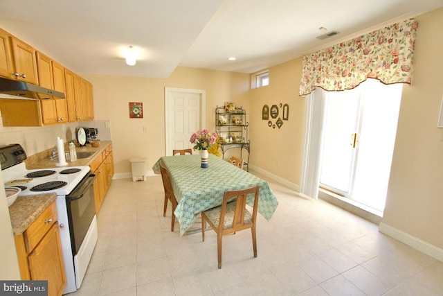 kitchen with under cabinet range hood, visible vents, electric stove, and baseboards