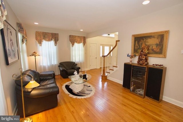 living area with recessed lighting, stairs, baseboards, and wood finished floors