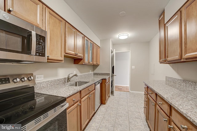 kitchen featuring brown cabinets, stainless steel appliances, and a sink