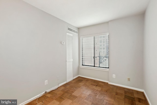 unfurnished room with baseboards and visible vents