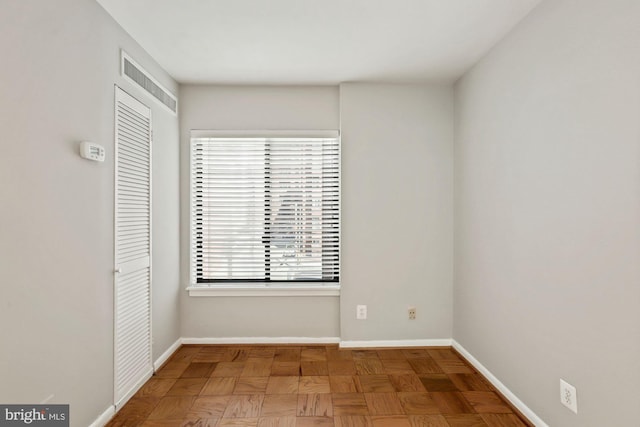 unfurnished room with visible vents and baseboards