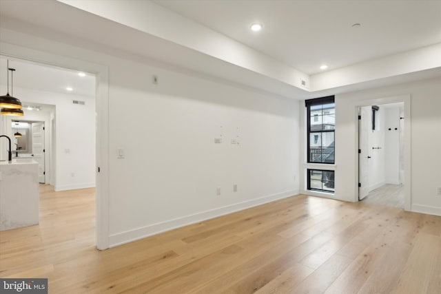 spare room featuring visible vents, recessed lighting, light wood-style floors, and baseboards