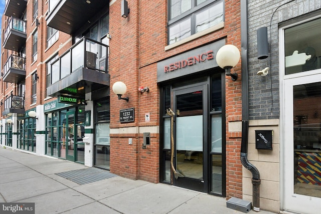 entrance to property featuring brick siding