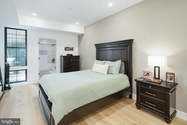 bedroom featuring recessed lighting, baseboards, light wood finished floors, and connected bathroom