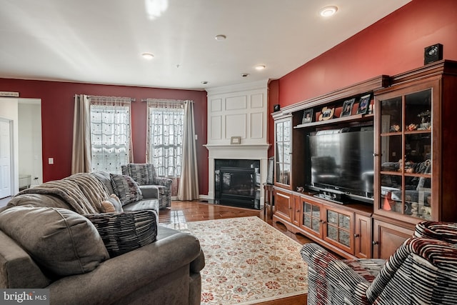 living room with recessed lighting, wood finished floors, and a fireplace