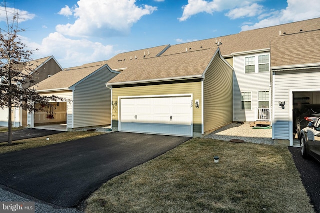 view of front of property featuring a garage, roof with shingles, and driveway