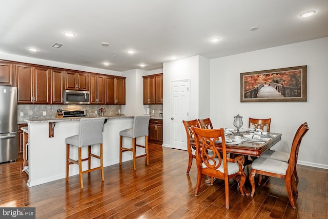 dining area featuring dark wood finished floors, recessed lighting, and visible vents