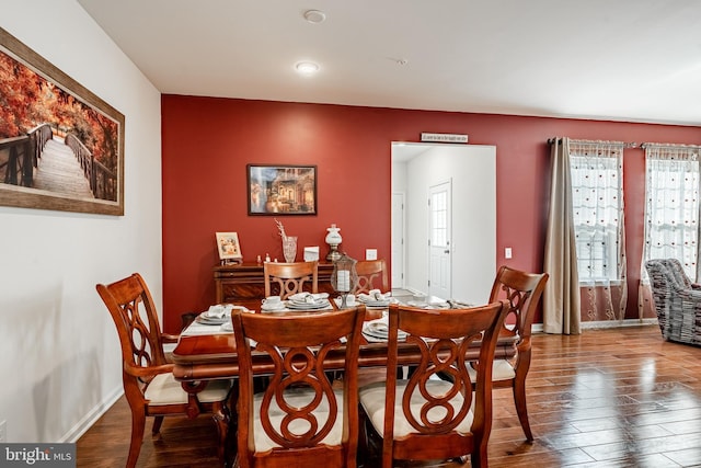 dining space featuring wood finished floors and baseboards