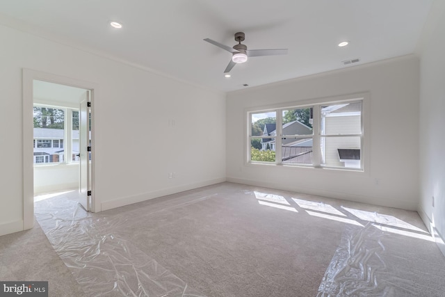 unfurnished room with carpet flooring, crown molding, plenty of natural light, and baseboards