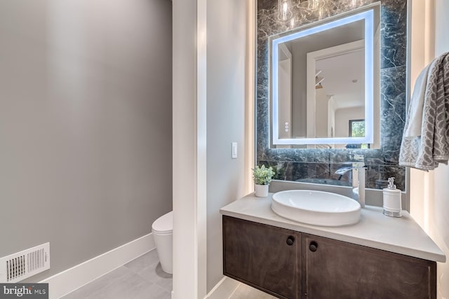 half bathroom with visible vents, toilet, decorative backsplash, baseboards, and vanity