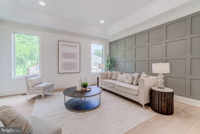 living room featuring recessed lighting, light wood finished floors, and a decorative wall