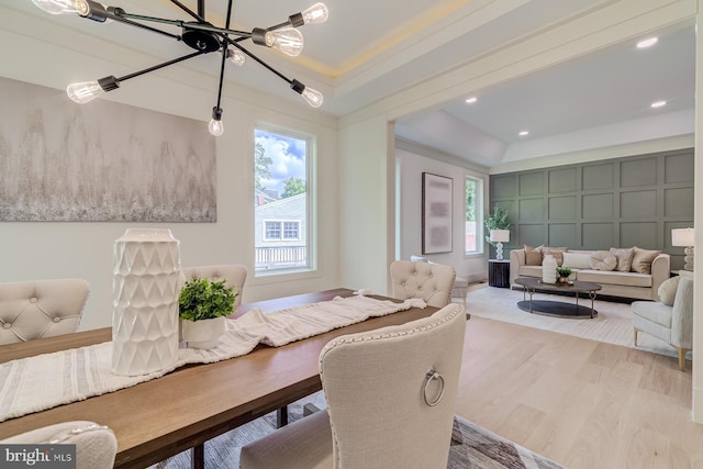 dining area with a tray ceiling, plenty of natural light, and wood finished floors