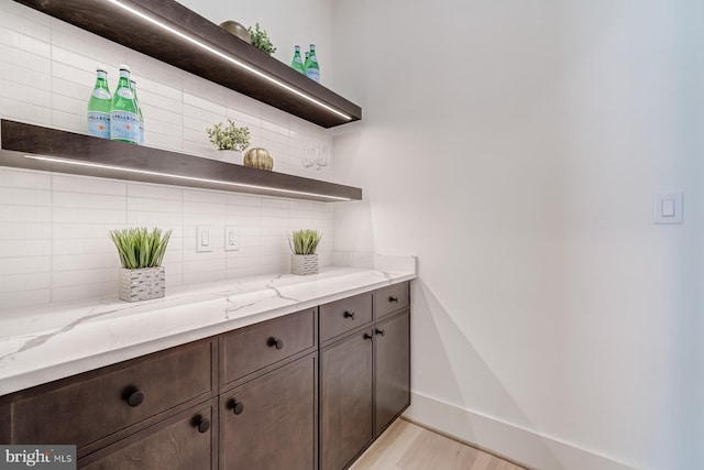 bar featuring decorative backsplash and baseboards