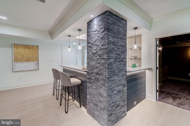 bar featuring wood finished floors, recessed lighting, baseboards, a dry bar, and hanging light fixtures