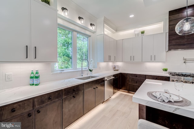 kitchen featuring a sink, light stone counters, backsplash, stainless steel dishwasher, and dark brown cabinets