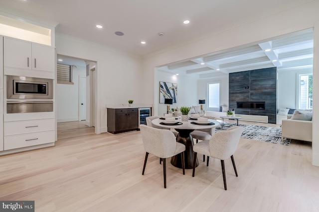 dining space featuring coffered ceiling, beam ceiling, recessed lighting, a fireplace, and light wood-type flooring