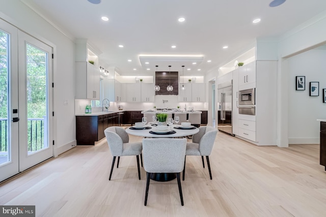 dining room featuring recessed lighting, light wood-style flooring, and ornamental molding