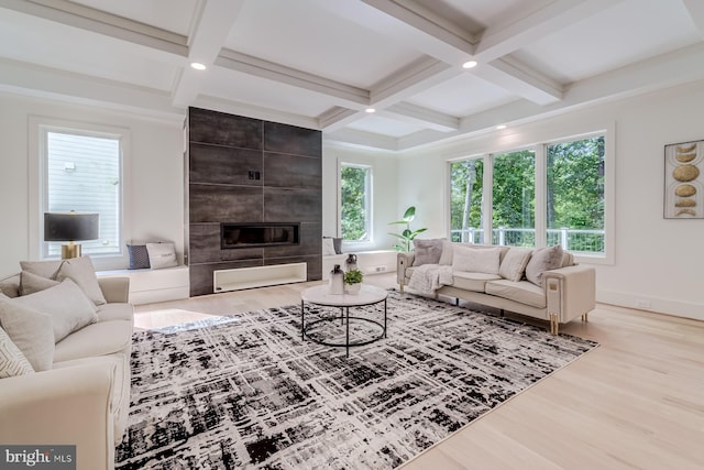 living area featuring beam ceiling, a fireplace, coffered ceiling, and wood finished floors