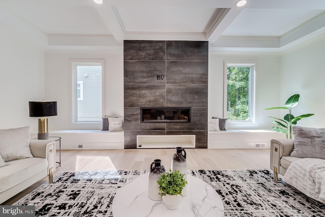 living room featuring visible vents, beam ceiling, wood finished floors, and a fireplace