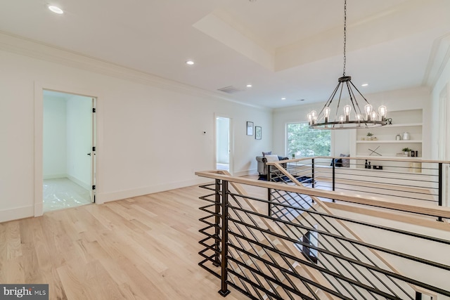 interior space with an upstairs landing, recessed lighting, light wood finished floors, and crown molding