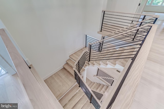 staircase with baseboards and wood finished floors