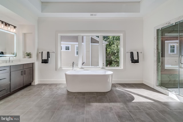 full bath with vanity, baseboards, visible vents, a freestanding tub, and a shower stall