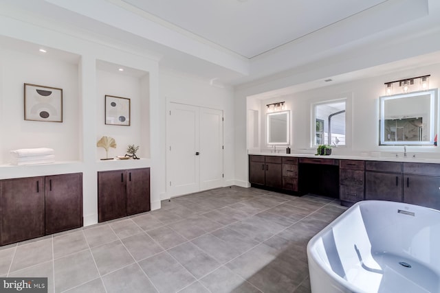 bathroom featuring a freestanding tub, crown molding, vanity, and tile patterned flooring