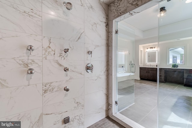 bathroom with vanity, tile patterned flooring, and a tile shower