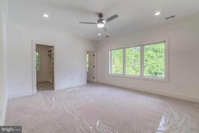 carpeted spare room featuring a ceiling fan, baseboards, visible vents, recessed lighting, and ornamental molding