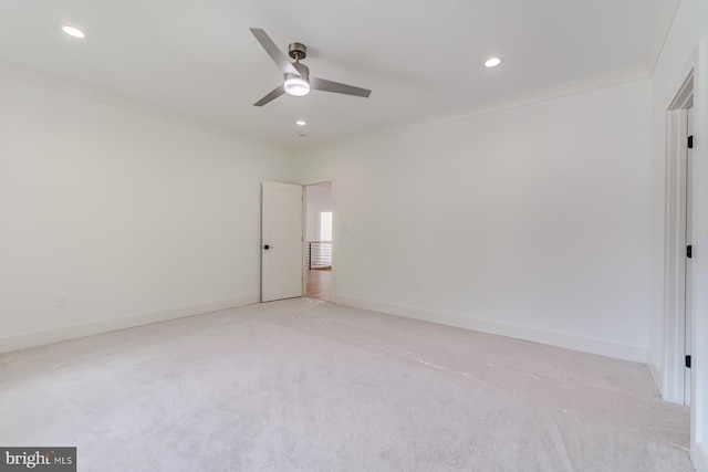 spare room with recessed lighting, light colored carpet, baseboards, and ornamental molding