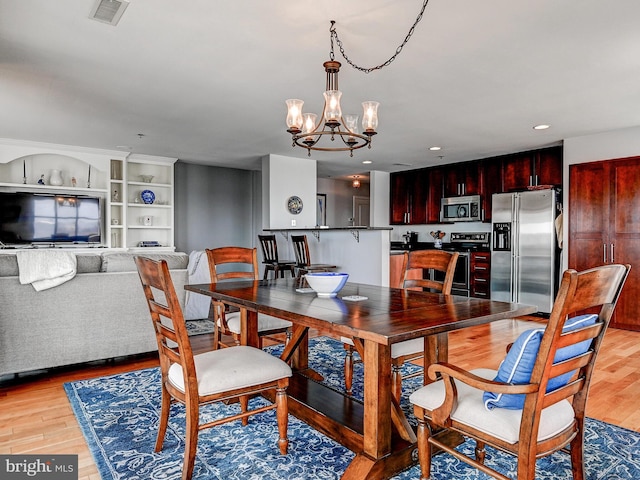 dining area with a notable chandelier, recessed lighting, visible vents, and light wood finished floors