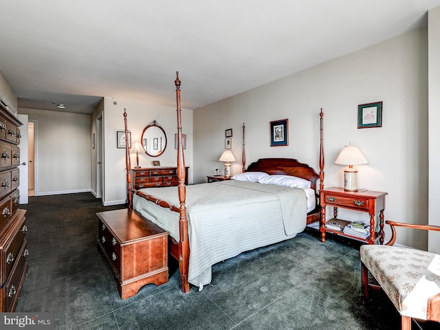 bedroom featuring baseboards and dark carpet