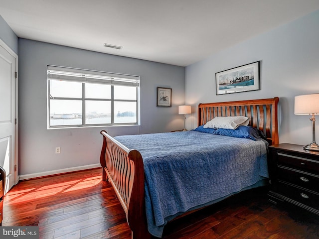 bedroom with visible vents, baseboards, and hardwood / wood-style floors