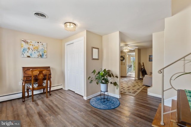 entryway featuring visible vents, a baseboard heating unit, baseboards, wood finished floors, and a ceiling fan