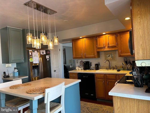 kitchen with a sink, decorative light fixtures, stainless steel appliances, brown cabinetry, and light countertops