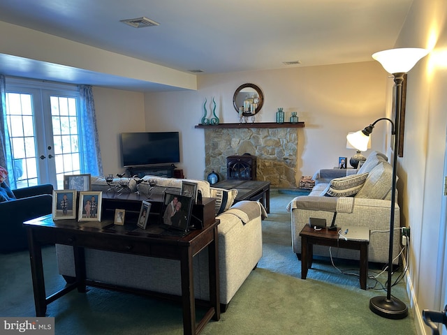 carpeted living area with visible vents, a fireplace, and french doors