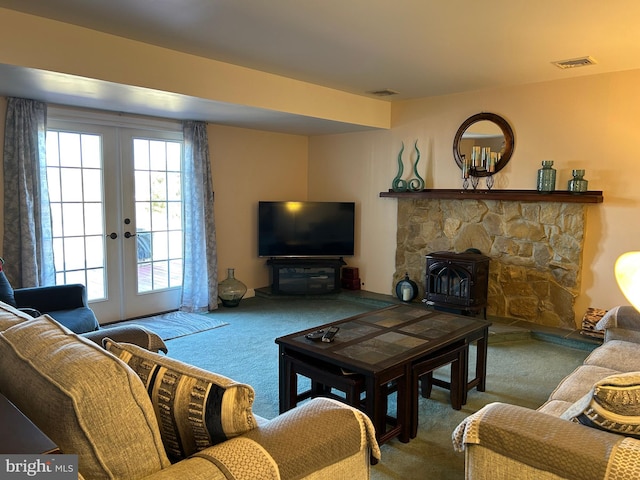 carpeted living area with a wood stove, french doors, and visible vents