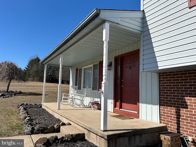 exterior space with brick siding and a porch