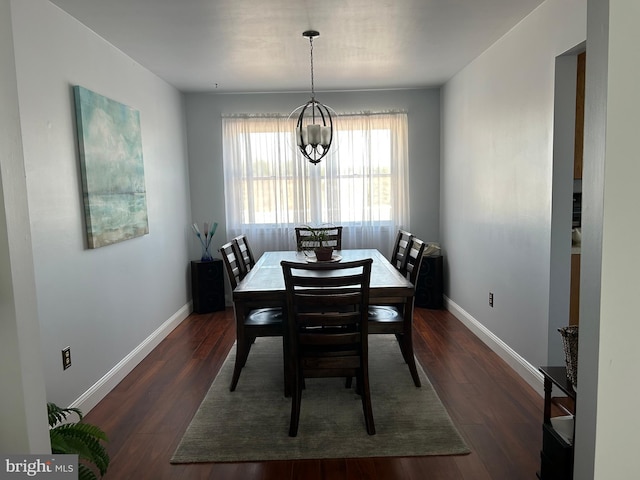 dining room with baseboards, dark wood-type flooring, and an inviting chandelier