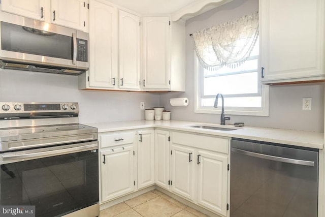 kitchen featuring white cabinetry, light countertops, appliances with stainless steel finishes, and a sink