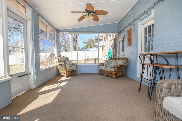 sunroom / solarium with ceiling fan and vaulted ceiling