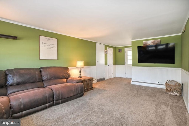 carpeted living room with crown molding and a wainscoted wall