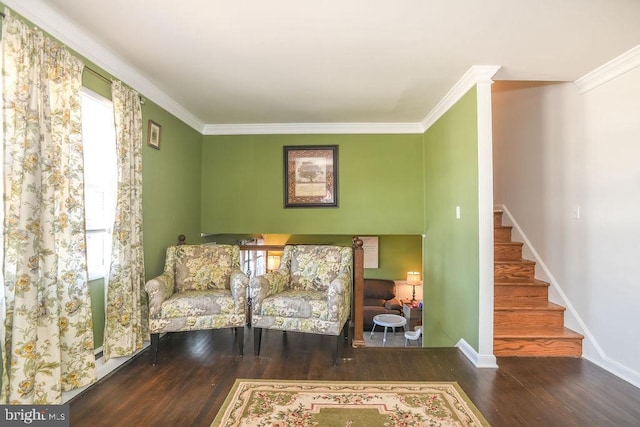 sitting room with wood finished floors, crown molding, baseboards, stairs, and ornate columns