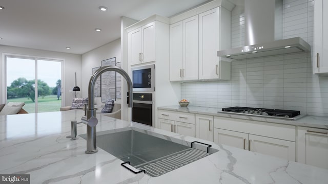 kitchen featuring wall oven, wall chimney range hood, stainless steel gas cooktop, built in microwave, and white cabinetry